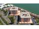 Aerial view of waterfront condo buildings, lush landscaping, and a serene pond within the community at 7432 Sunshine Skyway S Ln # 406, St Petersburg, FL 33711