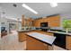 Bright kitchen with an island, tile flooring, wood cabinets, and modern black appliances at 7537 Old Pasco Rd, Wesley Chapel, FL 33544