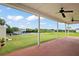 Covered patio with ceiling fans showcases views of the expansive backyard, dock, and tranquil waterfront at 8932 Rocky Creek Dr, Tampa, FL 33615