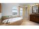 Bright bathroom featuring a soaking tub, shower, and large window at 8932 Rocky Creek Dr, Tampa, FL 33615
