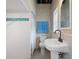 The bathroom features a pedestal sink, ceramic tiling, and shower, offering a convenient and functional space at 8932 Rocky Creek Dr, Tampa, FL 33615