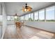 A sunroom that provides natural light, ceiling fans, and wood look vinyl flooring at 8932 Rocky Creek Dr, Tampa, FL 33615