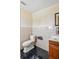 Bathroom featuring a toilet, vanity and mirror with a dark tiled floor at 8940 Rocky Creek Dr, Tampa, FL 33615