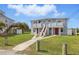 Light blue two-story home features red doors, elevated porches, and a walkway, with green lawn extending to other houses at 8940 Rocky Creek Dr, Tampa, FL 33615