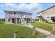 Two-story light blue home with bright red doors and elevated porches, complemented by a well-maintained lawn and pathway at 8940 Rocky Creek Dr, Tampa, FL 33615