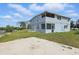 Two-story light blue home features a screened balcony and patio, with lush grass extending to the waterfront at 8940 Rocky Creek Dr, Tampa, FL 33615