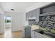 Bright kitchen features gray cabinetry, mosaic backsplash, and a window view at 8940 Rocky Creek Dr, Tampa, FL 33615