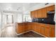 Well lit kitchen with wood cabinets, tile backsplash, and stainless steel double sink at 8940 Rocky Creek Dr, Tampa, FL 33615