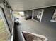 Wide view of a screened lanai with seating, lights, and sliding door entry at 9815 Wayside Ln, Port Richey, FL 34668