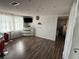 Bright living room featuring modern white brick wall with decorative accents and wood-look flooring at 9815 Wayside Ln, Port Richey, FL 34668