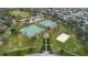 Aerial view featuring tennis courts, a basketball court, and a sand volleyball court surrounded by lush greenery at 10728 Navigation Dr, Riverview, FL 33579