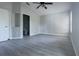 Empty bedroom with gray floors, ceiling fan, a closet, and a view of the en-suite bathroom at 10728 Navigation Dr, Riverview, FL 33579