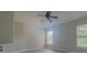 A well-lit bedroom provides a tranquil atmosphere with natural light, a ceiling fan, and gray flooring at 10728 Navigation Dr, Riverview, FL 33579