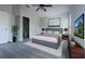 This spacious bedroom features a stylish gray bed frame, sleek ceiling fan, and luxury vinyl flooring at 10728 Navigation Dr, Riverview, FL 33579