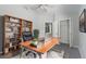 Home office space with gray floors, a ceiling fan, a live-edge desk and a bookshelf at 10728 Navigation Dr, Riverview, FL 33579