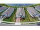 An aerial view of a home in a planned community, showcasing its well-maintained lawn and proximity to a beautiful lake at 11773 Little River Way, Parrish, FL 34219