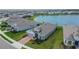 Overhead view of a modern single-Gathering home with manicured lawn, in a community near a scenic pond at 11773 Little River Way, Parrish, FL 34219
