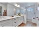Bright bathroom featuring double sink vanity, framed mirror, and glass-enclosed shower with natural light at 11773 Little River Way, Parrish, FL 34219