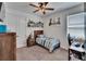 Bedroom with a wooden bed frame, built in shelving, ceiling fan, and window at 11773 Little River Way, Parrish, FL 34219