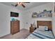 Bedroom with a wooden bed frame, built in shelving, ceiling fan, and window at 11773 Little River Way, Parrish, FL 34219