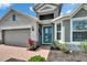 Inviting home entrance with brick walkway, manicured landscaping, and a striking teal front door at 11773 Little River Way, Parrish, FL 34219
