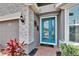 Charming front entrance with brick walkway, modern light fixture, and a vibrant teal front door at 11773 Little River Way, Parrish, FL 34219