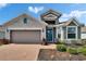Charming home with a brick walkway, gray stone accents, teal door, well-maintained landscaping, and a two-car garage at 11773 Little River Way, Parrish, FL 34219