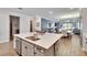 Open-concept kitchen showcasing a large island with a sink, stainless steel appliances, and seamless flow to living areas at 11773 Little River Way, Parrish, FL 34219