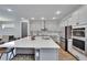 Bright kitchen featuring an expansive island, stainless steel appliances, and modern white cabinetry at 11773 Little River Way, Parrish, FL 34219