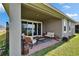 Charming covered patio with sliding glass doors, pleasant seating, and a lush backyard overlooking the tranquil lake at 11773 Little River Way, Parrish, FL 34219