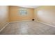 Clean, blank-slate bedroom with tiled floors, neutral walls, and a window for natural light at 122 N Kings Ave # 101, Brandon, FL 33510