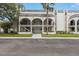 Charming condo building with an elegant arched entryway and lush landscaping at 122 N Kings Ave # 101, Brandon, FL 33510