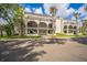 Inviting condo building with archways, second-floor balconies, lush landscaping, and well-maintained sidewalks at 122 N Kings Ave # 101, Brandon, FL 33510