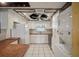 Efficient kitchen featuring white cabinetry, neutral countertops, and a combination washer-dryer unit at 122 N Kings Ave # 101, Brandon, FL 33510