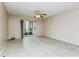 Bright living room with tiled floor, ceiling fan, and sliding glass doors leading to outdoor space at 122 N Kings Ave # 101, Brandon, FL 33510