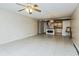Open-concept living room showcasing tiled floors, a ceiling fan, and a seamless transition to the kitchen at 122 N Kings Ave # 101, Brandon, FL 33510