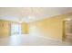 Bright living room features tile floors, ceiling fan, and sliding glass doors to the outside patio at 122 N Kings Ave # 101, Brandon, FL 33510