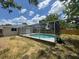 View of the screened-in pool and the back of the house in the backyard at 12801 College Hill Dr, Hudson, FL 34667