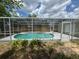 Screened-in pool with a concrete deck, plants, and pool equipment near the house at 12801 College Hill Dr, Hudson, FL 34667