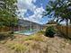 Backyard with a screened-in pool and a well-maintained wood fence at 12801 College Hill Dr, Hudson, FL 34667