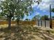 View of the backyard shed near a wood fence in a yard with trees at 12801 College Hill Dr, Hudson, FL 34667