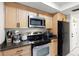 Updated kitchen with stainless steel appliances, light wood cabinets, and dark countertops at 13512 Palmwood Ln # 13512, Tampa, FL 33618