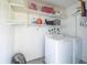 Functional laundry area with a washer, dryer, and shelving for storage of supplies and cleaning products at 13512 Palmwood Ln # 13512, Tampa, FL 33618