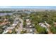 Stunning aerial view of a residential area with lush trees, pools, and glimpses of the ocean in the background at 14199 82Nd Avenue, Seminole, FL 33776