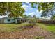 Backyard with a well-maintained lawn, trees, and a glimpse of the home's exterior, creating a private outdoor retreat at 14199 82Nd Avenue, Seminole, FL 33776
