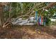 Backyard scene featuring wind chimes and an owl statue hanging from the tree, offering a peaceful outdoor setting at 14199 82Nd Avenue, Seminole, FL 33776