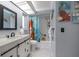 Cozy bathroom features a modern vanity, tub-shower combo, skylight, and stylish decor, creating a relaxing atmosphere at 14199 82Nd Avenue, Seminole, FL 33776