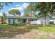 Charming single-story home with a well-manicured lawn, mature trees, and a light blue exterior paint at 14199 82Nd Avenue, Seminole, FL 33776