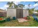 Storage shed with double doors, surrounded by plants and garden decorations, providing ample storage space at 14199 82Nd Avenue, Seminole, FL 33776