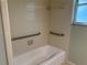 Bathroom features white tile walls and a white bathtub with supportive grab bars for accessibility at 1902 W Aileen St, Tampa, FL 33607